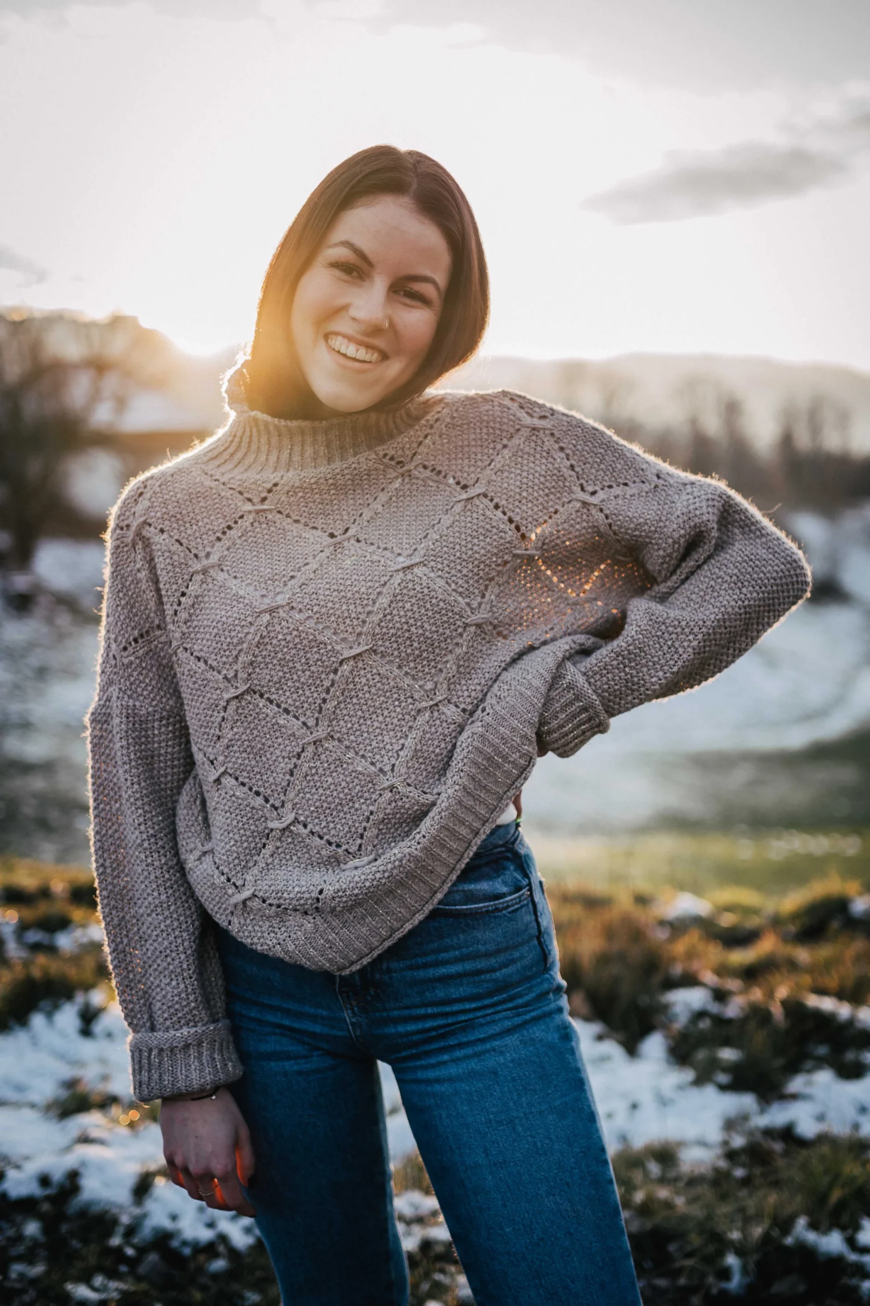 Sonnenuntergang Wintershooting von einer jungen Frau mit eingestützem Arm